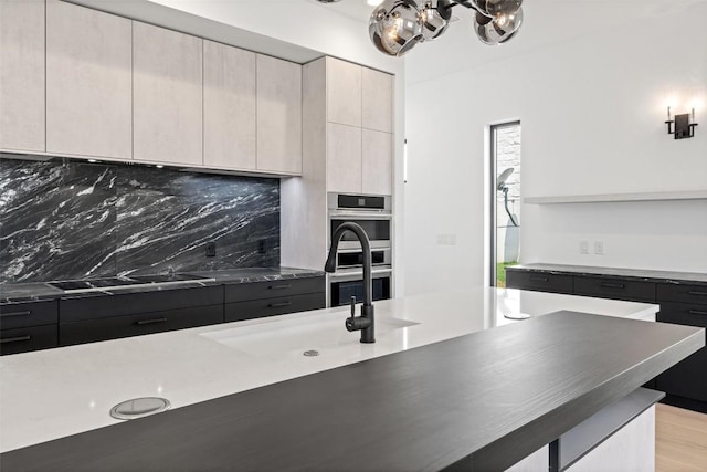 201 Custers Last Stand, Horseshoe Bay, TX 78657 - kitchen with black electric cooktop, tasteful backsplash, modern cabinets, and a chandelier