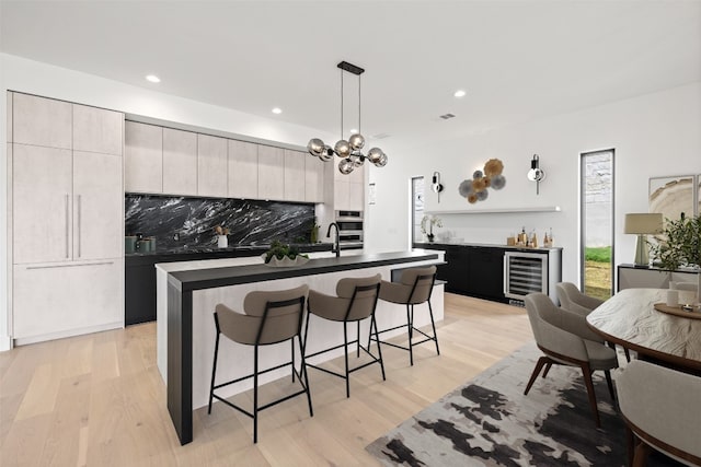 201 Custers Last Stand, Horseshoe Bay, TX 78657 - kitchen with wine cooler, a breakfast bar area, backsplash, dark countertops, and an island with sink