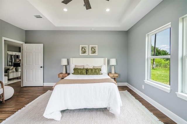 367 Stockade Ranch Rd, Paige, TX 78659 - bedroom with dark wood-type flooring, stainless steel refrigerator with ice dispenser, baseboards, a raised ceiling, and a ceiling fan