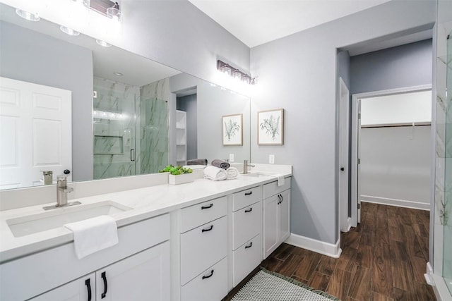 367 Stockade Ranch Rd, Paige, TX 78659 - full bathroom with a marble finish shower, double vanity, wood finished floors, a spacious closet, and baseboards