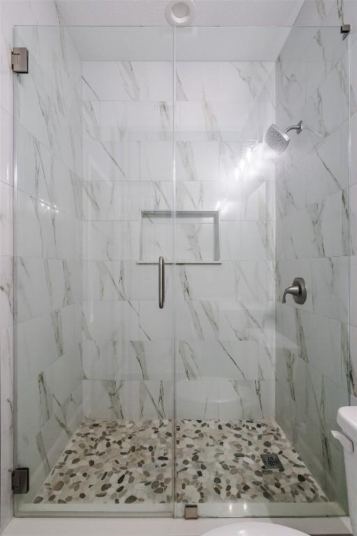 367 Stockade Ranch Rd, Paige, TX 78659 - bathroom with a marble finish shower and toilet