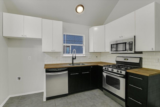 501 Maple Run, Round Rock, TX 78664 - kitchen with appliances with stainless steel finishes, butcher block counters, a sink, dark cabinetry, and white cabinets