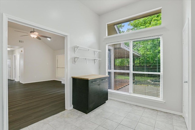 501 Maple Run, Round Rock, TX 78664 - kitchen featuring baseboards, dark cabinets, ceiling fan, light tile patterned floors, and high vaulted ceiling