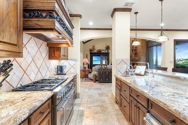 104 Porto Cima Ct, Austin, TX 78738 - kitchen with range with two ovens, brown cabinetry, stone tile floors, tasteful backsplash, and crown molding