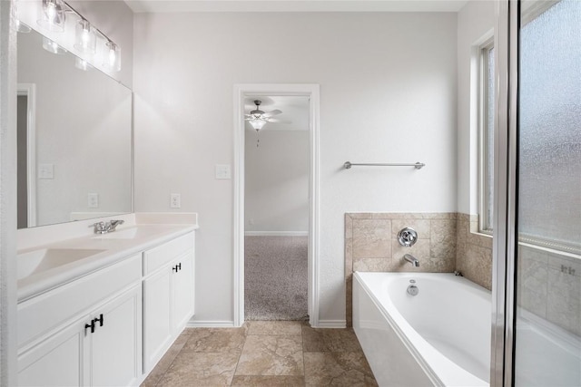 111 Colthorpe Ln, Hutto, TX 78634 - bathroom with double vanity, a garden tub, a ceiling fan, and baseboards