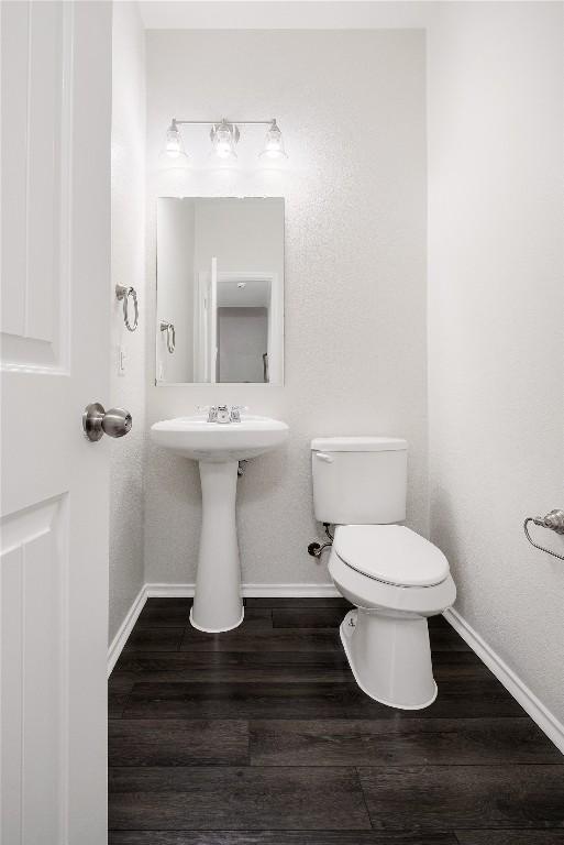 111 Colthorpe Ln, Hutto, TX 78634 - bathroom featuring baseboards, toilet, wood finished floors, and a sink