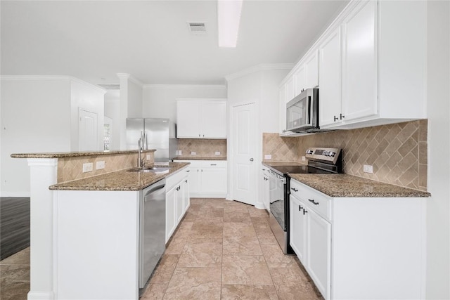 111 Colthorpe Ln, Hutto, TX 78634 - kitchen with appliances with stainless steel finishes, a sink, a center island with sink, stone counters, and white cabinetry