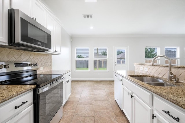 111 Colthorpe Ln, Hutto, TX 78634 - kitchen with stainless steel appliances, a sink, backsplash, crown molding, and white cabinetry