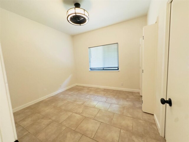 5504 Montview St, Austin, TX 78756 - spare room with light tile patterned floors and baseboards