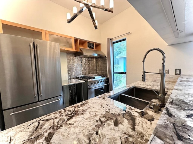 5504 Montview St, Austin, TX 78756 - kitchen with stainless steel appliances, extractor fan, backsplash, and light stone countertops