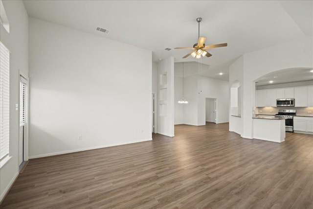 423 Leadtree Loop, Buda, TX 78610 - unfurnished living room featuring a ceiling fan, dark wood finished floors, recessed lighting, a chandelier, and arched walkways