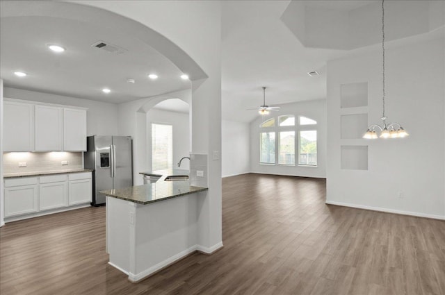 423 Leadtree Loop, Buda, TX 78610 - kitchen featuring stainless steel refrigerator with ice dispenser, arched walkways, dark wood finished floors, backsplash, and white cabinets