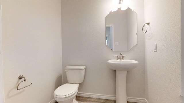 210 Dewey Dr, Killeen, TX 76542 - bathroom with toilet, a sink, wood finished floors, and baseboards