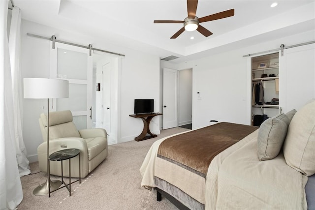 208 Honey Creek Ct Unit 29, Austin, TX 78738 - bedroom featuring a barn door, light carpet, a raised ceiling, recessed lighting, and a ceiling fan