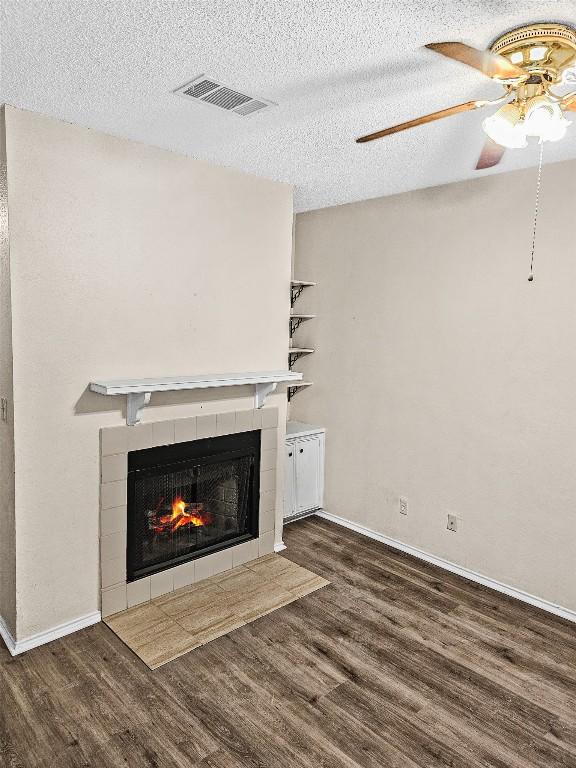 2706 Salado St Unit 205, Austin, TX 78705 - unfurnished living room with wood finished floors, a ceiling fan, a fireplace, baseboards, and a textured ceiling