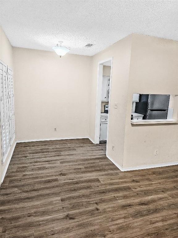 2706 Salado St Unit 205, Austin, TX 78705 - unfurnished living room with a textured ceiling, dark wood-style floors, and baseboards