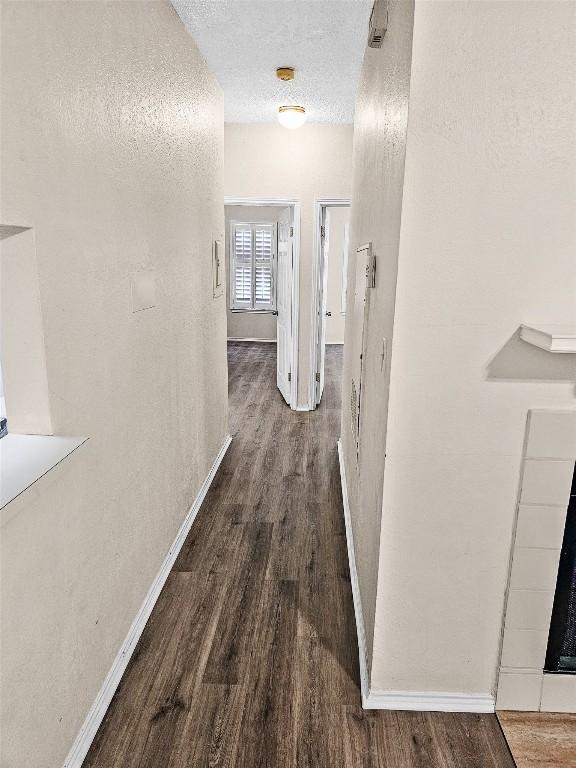 2706 Salado St Unit 205, Austin, TX 78705 - corridor featuring wood finished floors, baseboards, and a textured ceiling