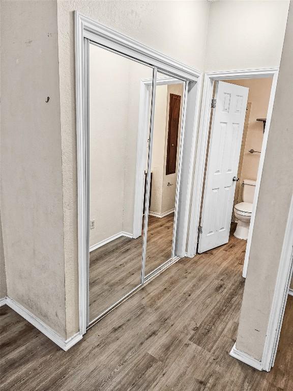 2706 Salado St Unit 205, Austin, TX 78705 - unfurnished bedroom featuring a closet, wood finished floors, baseboards, and ensuite bathroom