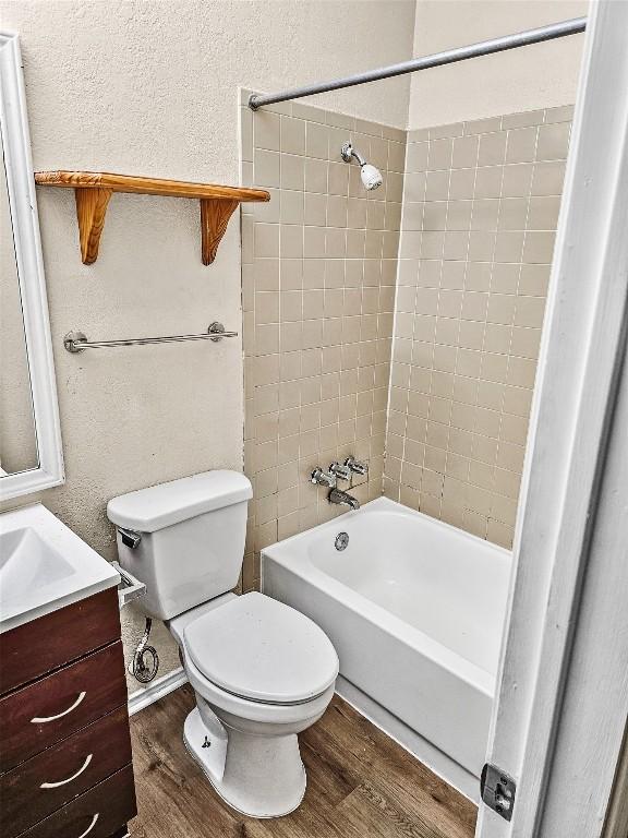 2706 Salado St Unit 205, Austin, TX 78705 - full bath with wood finished floors, toilet, vanity, shower / bath combination, and a textured wall