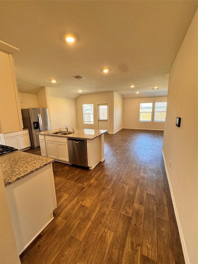 322 Harvest Creek Dr, Kyle, TX 78640 - kitchen featuring stainless steel appliances, dark wood finished floors, a center island with sink, open floor plan, and white cabinets