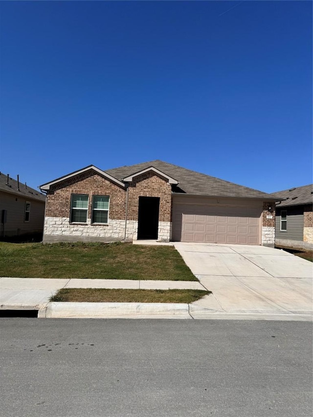 322 Harvest Creek Dr, Kyle, TX 78640 - ranch-style house with brick siding, a garage, driveway, and a front yard