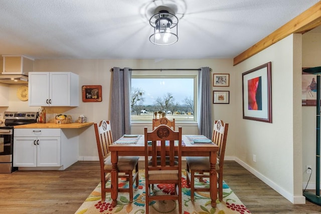 2340 E State Highway 71, Llano, TX 78643 - dining area featuring light wood-style flooring, baseboards, and a textured ceiling