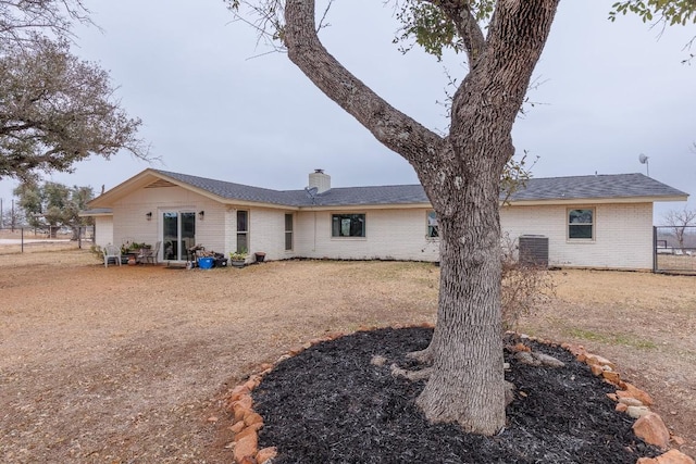 2340 E State Highway 71, Llano, TX 78643 - back of house featuring brick siding, a chimney, and central air condition unit