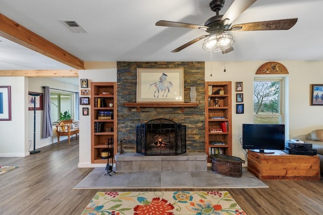 2340 E State Highway 71, Llano, TX 78643 - living area with plenty of natural light, wood finished floors, a ceiling fan, and a fireplace