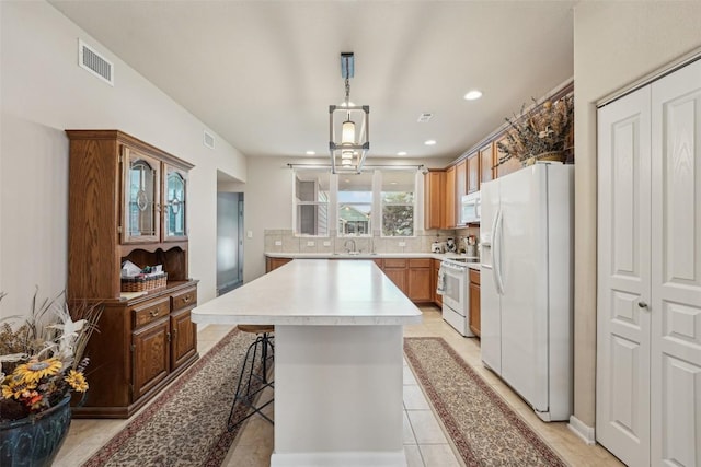 1261 Nevarez, Kyle, TX 78640 - kitchen with white appliances, decorative backsplash, a center island, recessed lighting, and light countertops