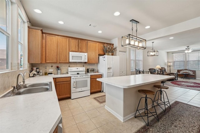 1261 Nevarez, Kyle, TX 78640 - kitchen with white appliances, a breakfast bar area, light tile patterned floors, backsplash, and brown cabinetry