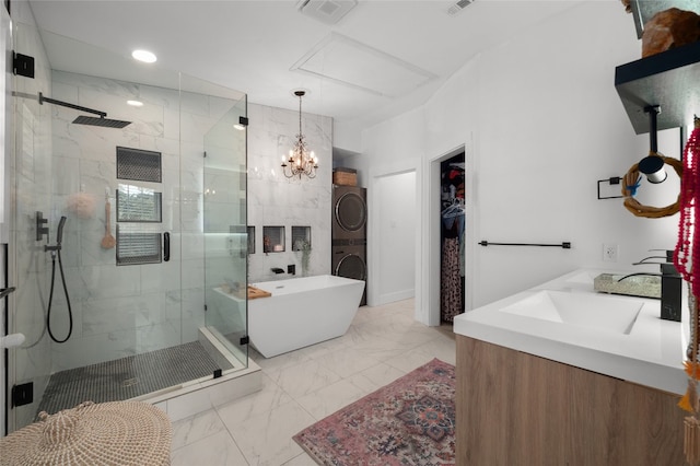 120 Acapulco Dr, Lakeway, TX 78734 - full bath with stacked washer / drying machine, marble look tile flooring, a shower stall, a soaking tub, and double vanity