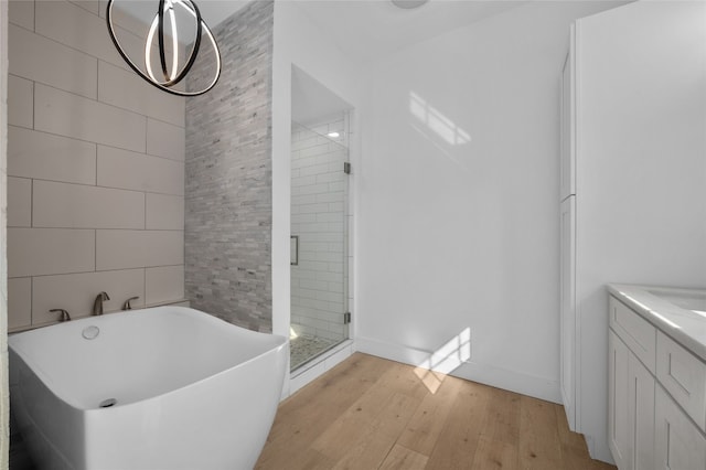 120 Acapulco Dr, Lakeway, TX 78734 - bathroom featuring a stall shower, wood finished floors, a freestanding bath, vanity, and tile walls