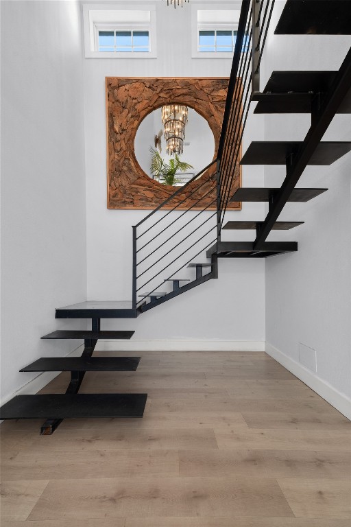 120 Acapulco Dr, Lakeway, TX 78734 - staircase featuring a chandelier, baseboards, wood finished floors, and plenty of natural light
