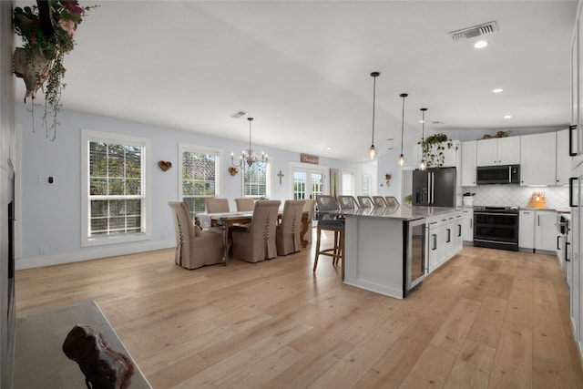 120 Acapulco Dr, Lakeway, TX 78734 - kitchen featuring stainless steel appliances, light wood finished floors, a breakfast bar area, tasteful backsplash, and recessed lighting