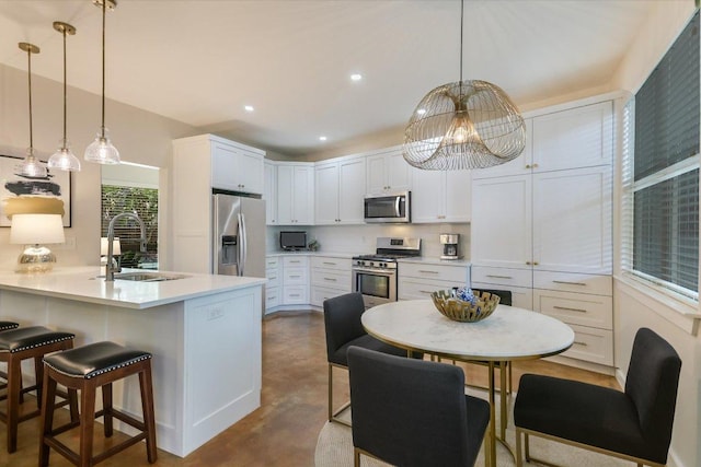 2114 Goodrich Ave Unit 3, Austin, TX 78704 - kitchen with stainless steel appliances, a sink, a kitchen breakfast bar, concrete floors, and a peninsula