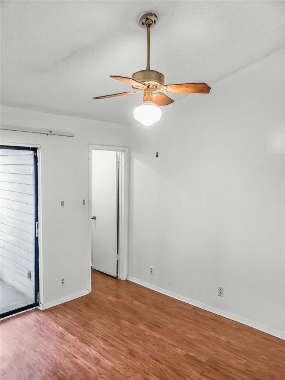 106 E 30th St Unit 305, Austin, TX 78705 - empty room featuring wood finished floors, baseboards, and a ceiling fan