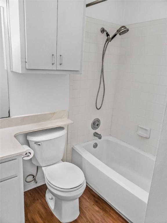 106 E 30th St Unit 305, Austin, TX 78705 - bathroom featuring vanity, wood finished floors, toilet, and shower / bathtub combination