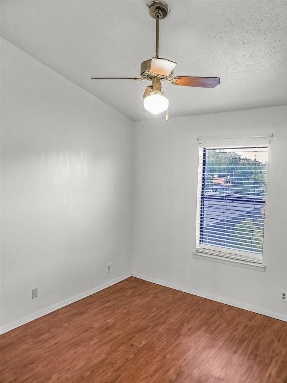 106 E 30th St Unit 305, Austin, TX 78705 - spare room with wood finished floors, a ceiling fan, and baseboards