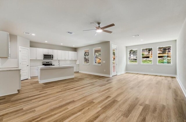 21710 Patton Dr, Lago Vista, TX 78645 - unfurnished living room with ceiling fan, light wood finished floors, baseboards, a sink, and recessed lighting