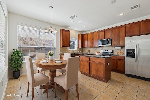 14009 Rountree Ranch Ln, Austin, TX 78717 - kitchen featuring stainless steel appliances, decorative backsplash, dark countertops, a chandelier, and a kitchen island