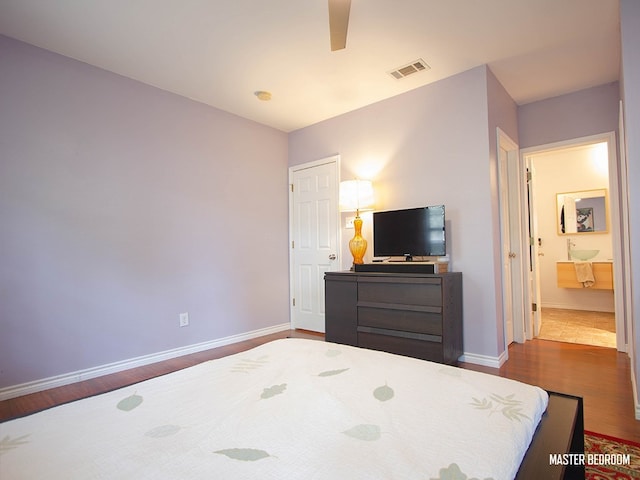 1808 Maple Ave, Austin, TX 78702 - bedroom featuring dark wood finished floors, baseboards, a ceiling fan, and connected bathroom