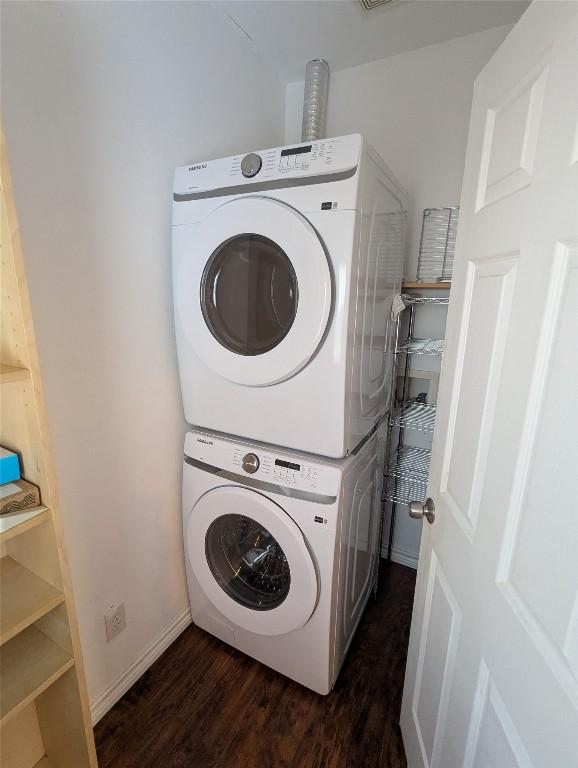1808 Maple Ave, Austin, TX 78702 - washroom featuring estacked washer and dryer and dark wood-type flooring