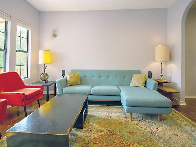 1808 Maple Ave, Austin, TX 78702 - living room featuring arched walkways, wood finished floors, and baseboards