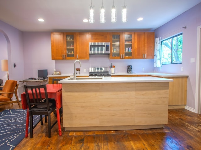 1808 Maple Ave, Austin, TX 78702 - kitchen with appliances with stainless steel finishes, brown cabinetry, light countertops, arched walkways, and recessed lighting