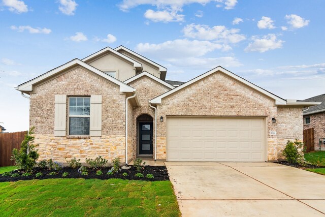 17900 Trieste Dr, Pflugerville, TX 78660 - view of front facade with stone siding, an attached garage, and driveway