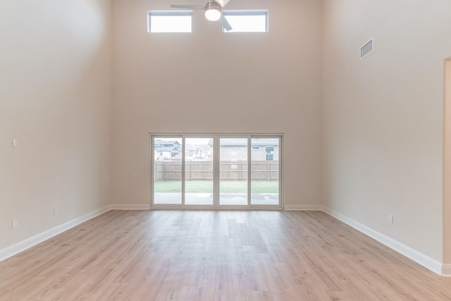 17900 Trieste Dr, Pflugerville, TX 78660 - empty room featuring a high ceiling, light wood-type flooring, ceiling fan, and baseboards
