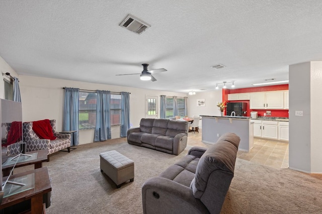 1207 Rolling Ridge Dr, Round Rock, TX 78665 - living area featuring light carpet, a textured ceiling, a ceiling fan, and light tile patterned floors