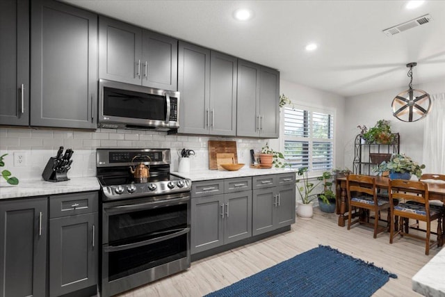 2003 Rain Water Dr, Austin, TX 78734 - kitchen with appliances with stainless steel finishes, tasteful backsplash, gray cabinetry, light wood-style floors, and recessed lighting