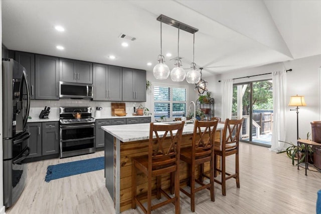 2003 Rain Water Dr, Austin, TX 78734 - kitchen featuring appliances with stainless steel finishes, gray cabinets, light wood-style floors, plenty of natural light, and recessed lighting