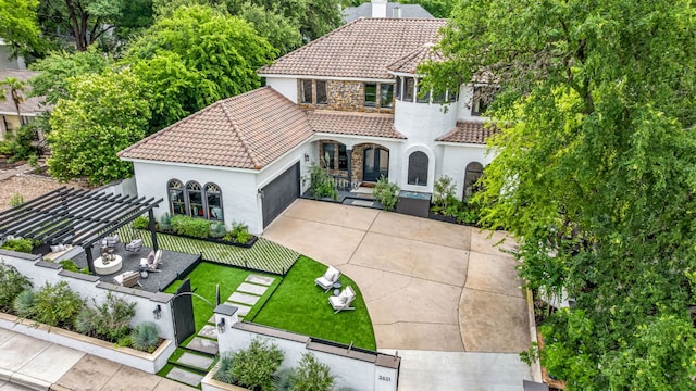2621 Exposition Blvd, Austin, TX 78703 - view of front of home with a tiled roof, stucco siding, concrete driveway, an attached garage, and a pergola